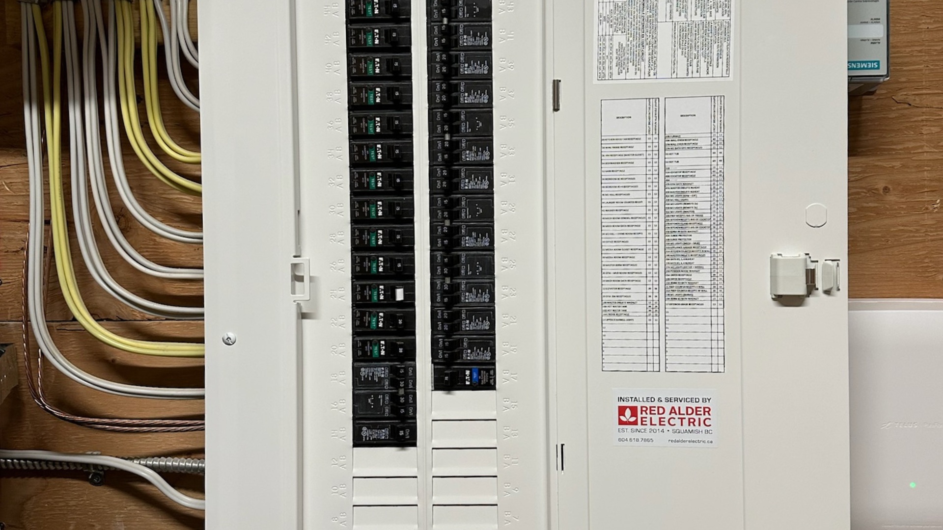 An open electrical panel with a Red Alder Electric sticker on it.